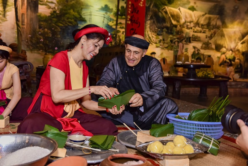 Foreigners enjoy wrapping Banh chung, traditional cake of Vietnamesee people during Tet holiday. (Photo: Vietnamplus)