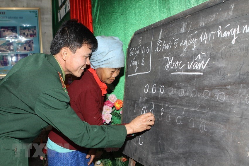 Soldiers at 575 Border Station teach Chut ethnic people in Rao Tre village, Huong Lien commune, Huong Khe district, Ha Tinh province how to read and write (Photo: VNA)