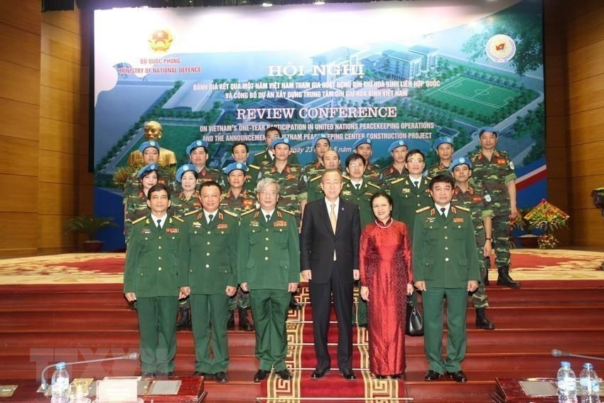 UN Secretary General Ban Ki-moon and Deputy Defence Minister Senior Lieutenant General Nguyen Chi Vinh pose in a group photo with delegates of the Vietnam Peacekeeping Centre at a meeting reviewing one year Vietnam join the UN peacekeeping mission in Hanoi, May 23, 2015 (Photo: Pham Kien)