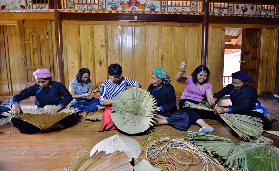 Tourists visiting Ban Lien experience the making of conical hats (Photo: VNP/VNA)