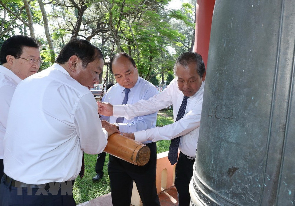 Prime Minister Nguyen Xuan Phuc strikes a bell at the cemetery (Photo: VNA)