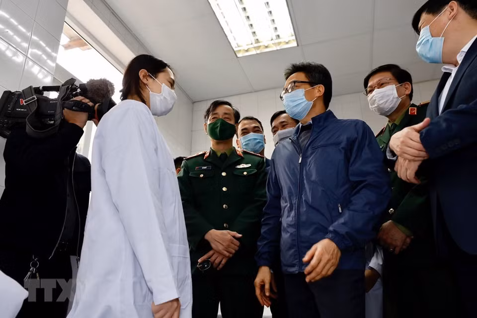The volunteers will stay at separate rooms at the Military Medical Academy for the first 72 hours for medical assessment. They will continue to be closely monitored at their residences for the next 56 days. In photo:Deputy Prime Minister Vu Duc Dam visits first cases of clinical trials of made-in-Vietnam COVID-19 vaccine Nano Covax (Photo: VNA)