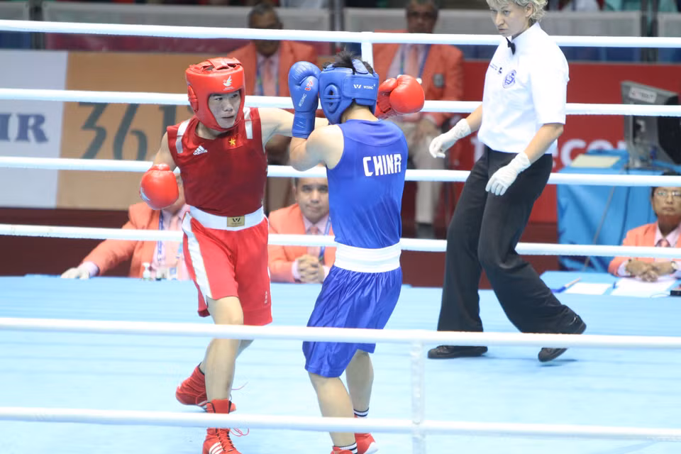 Female athlete Luu Thi Duyen (red) wins the first medal for Vietnamese boxing in continental sports events while competing at the 17th Asian Games in Incheon, the Republic of Korea, Sept. 30, 2014. (Photo: VNA)