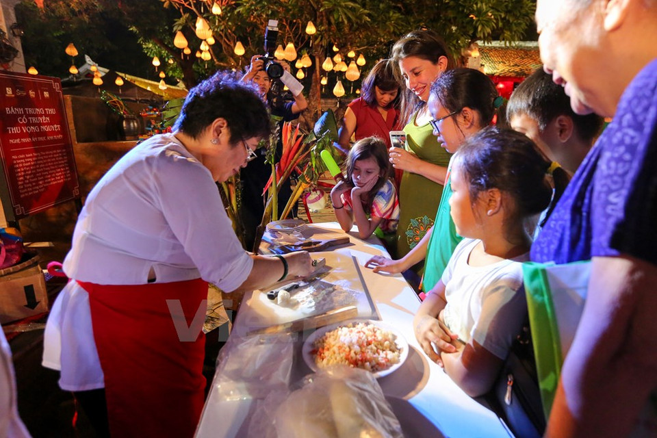 Visitors see how a mooncake is made. (Photo: VNA)