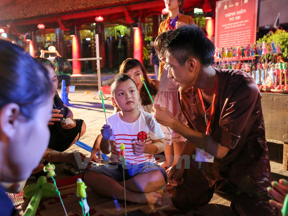A boy learns to craft a toy figurine (to he) himself. (Photo: VNA)