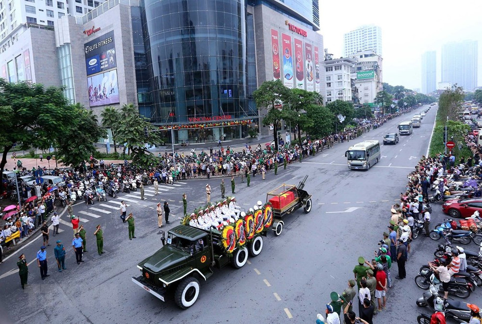The hearse carrying the President coffin goes through a street in Hanoi, followed by a long line of vehicles (Photo: VNA)