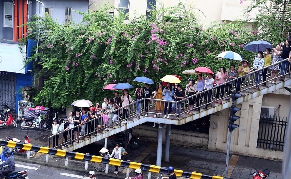 People stand along a staircase of a pedestrian bridge in Hanoi (Photo: VNA)