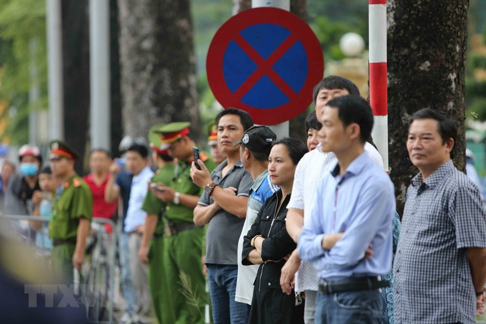 Hanoians stand along the road to pay homage to the President (Photo: VNA)
