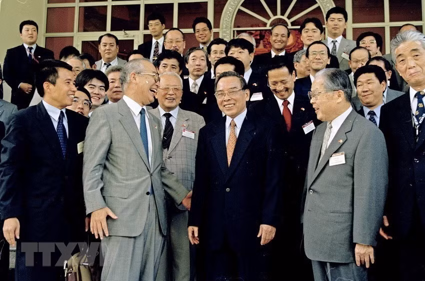 Prime Minister Phan Van Khai (centre, in black suit) and a delegation of the Japan External Trade Organisation (JETRO) led by Chairman and CEO Osamu Watanabe, in Hanoi on August 4, 2003. (Photo: VNA)