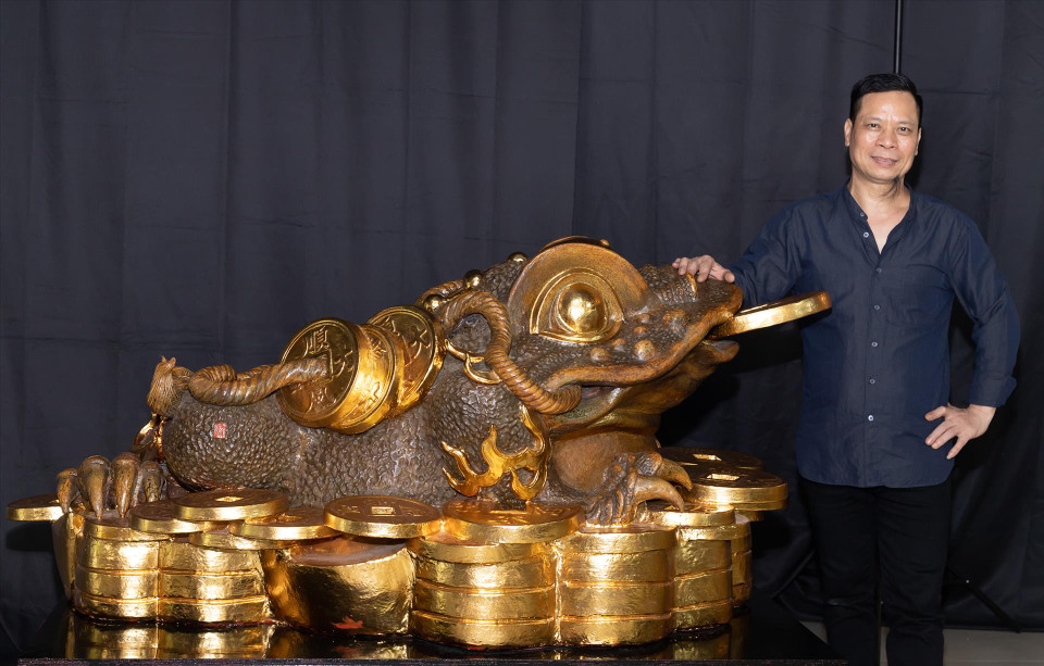 Artist Nguyen Hung and 'Thiem Thu Thien Phong An” – the Guinness world record for the largest ceramic sculpture of a mythical creature. It is a sculpture of a toad sitting on a pile of coins and gold bullion, which is 173.5cm long, 110cm wide and 77.8cm tall. (Photo: VNA)