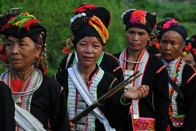 Kho Mu women carry a necessary item in crop-praying festival, bamboo stick, which is used by the shaman to predict whether the gods accept the villagers’ request (Photo: VNA)