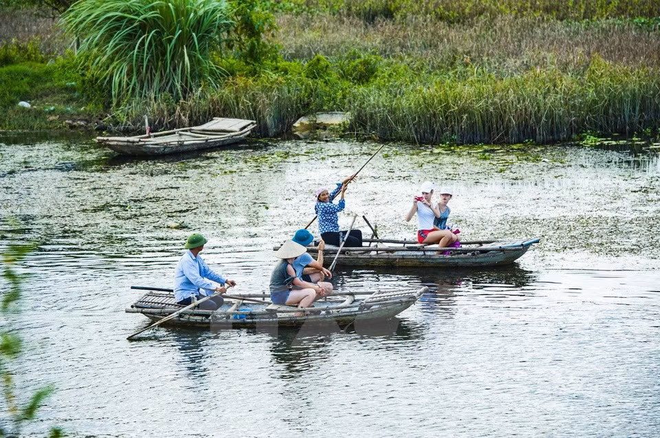 Local people paddle boats carrying tourists (Photo: VNA)