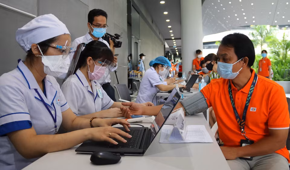 Doctors in Thu Duc, Ho Chi Minh City perform health examination for employees at FPT Software Company Limited before vaccination. (Photo: VNA)