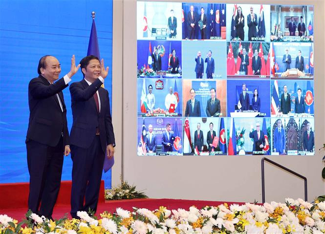 Prime Minister Nguyen Xuan Phuc and Minister of Industry and Trade Tran Tuan Anh greet participants at RCEP signing ceremony (Photo: VNA)
