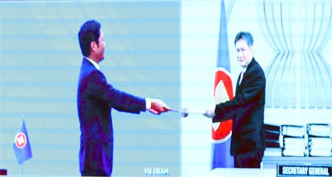 Vietnamese Minister of Industry and Trade Tran Tuan Anh symbolically hands over the signed copyrighting to ASEAN Secretary General Lim Jock Hoi (Photo: VNA)