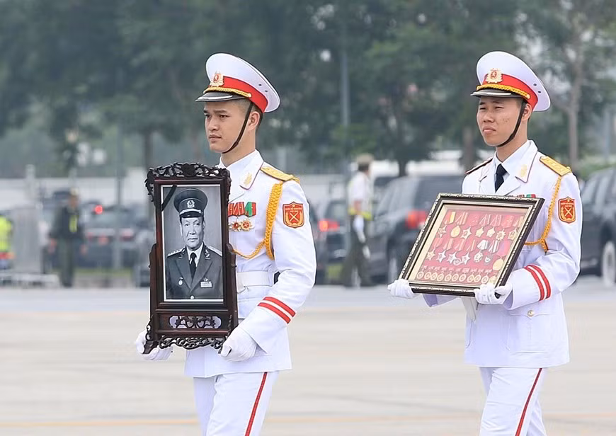 A soldier holds up a portrait of former President General Le Duc Anh (Photo: VNA)