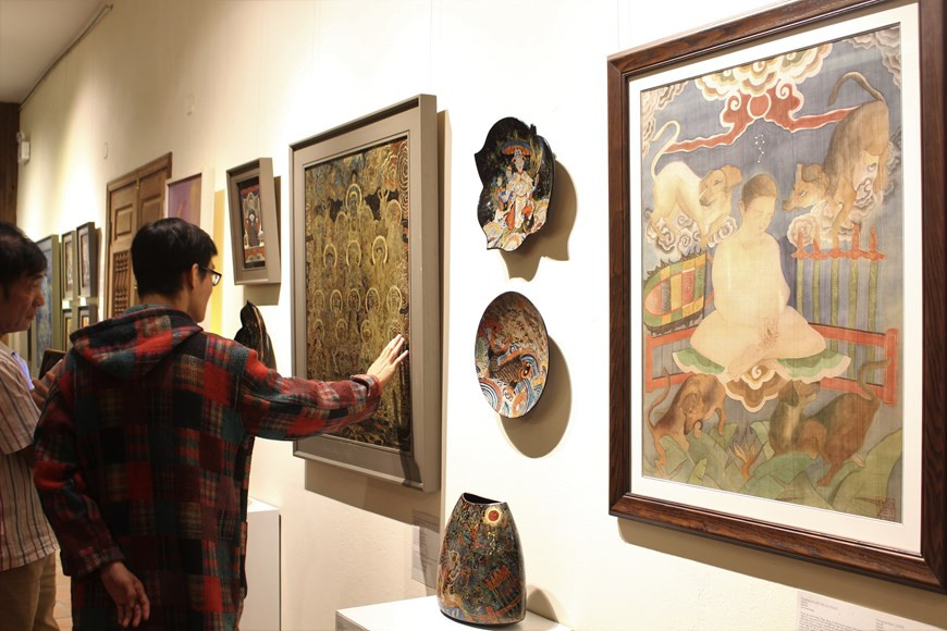 Like other traditional art genres in the country, Hang Trong painting has been facing the risk of falling into oblivion. The items on display are part of a project that aims to uphold and bring into play values of the Hang Trong folk painting genre by recreating the traditional paintings with silk and lacquer, giving them a more modern look. Nguyen The Son, a lecturer at the painting faculty of the Vietnam University of Fine Arts and also one of the authors’ supervisors, said this is also a new learning method when students are required to copy traditional folk paintings as part of their homework (Photo: VietnamPlus)