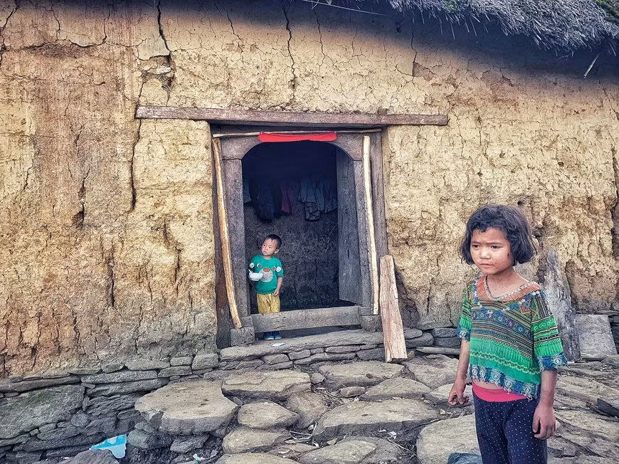 Ha Nhi ethnic children wait for adults to return from work in front of a ‘trinh tuong’ house. The construction of rammed earth houses starts with the building and setup of a stone foundation. Then, clay is compressed into moulds to make walls for the house. A mould is 2 – 2.5 metres in length and 60 centimetres in width. This is the most difficult step in the home building process. Although all steps are done manually without cement, these houses are very solid and firm. These houses have small doors and windows to prevent cold fog, winds and rains from entering. They provide a shelter that is cool in summer and warm in winter for their owners (Photo: VietnamPlus)