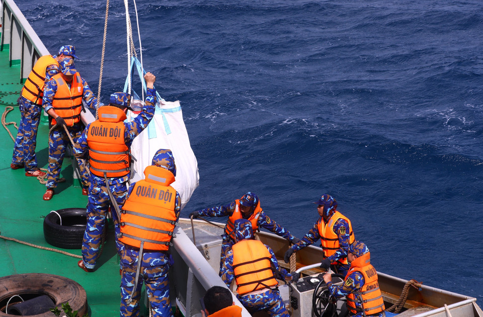 Soldiers carry gifts and goods on to ships. (Photo: VNA)