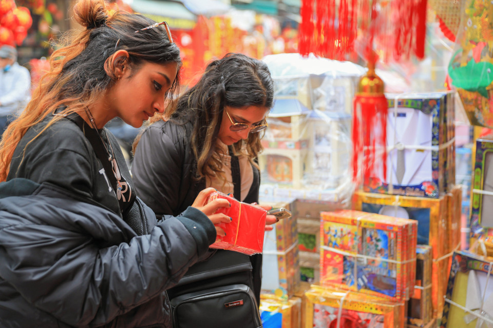 Foreign tourists seek lucky money envelopes. (Photo: VNA)