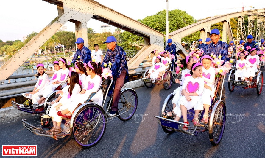 Cyclos carrying kids in Vietnamese traditional costume of ‘ao dai’ march around Hue city (Photo: VNA)