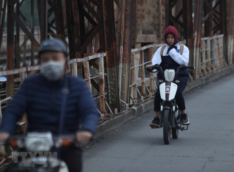 People crossing Long Bien bridge deeply feel the freezing cold spell (Photo: VNA)