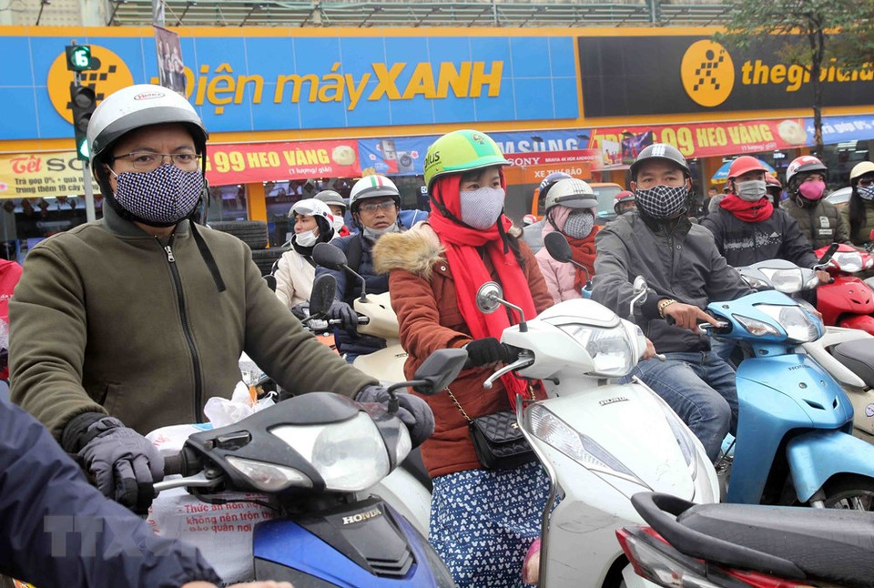 Warm clothes, face masks, wool scarfs and gloves are indispensable items for people during these days (Photo: VNA)