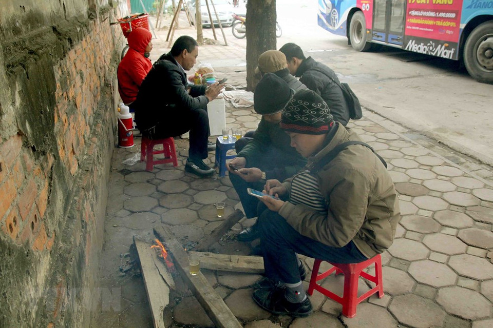 Some people on Tran Khanh Du street set a fire to heat them up (Photo: VNA) 