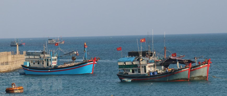 The national flag flutters on the mast of Vietnamese fishing vessels anchored on Da Tay A island (Truong Sa archipelago). (Photo: VNA) 