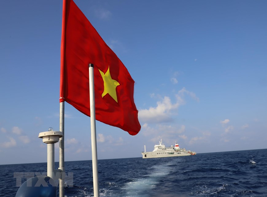 The national flag flutters on the mast of a motorboat carrying officers and soldiers of the Truong Sa 571 ship to Song Tu Tay island. (Photo: VNA)