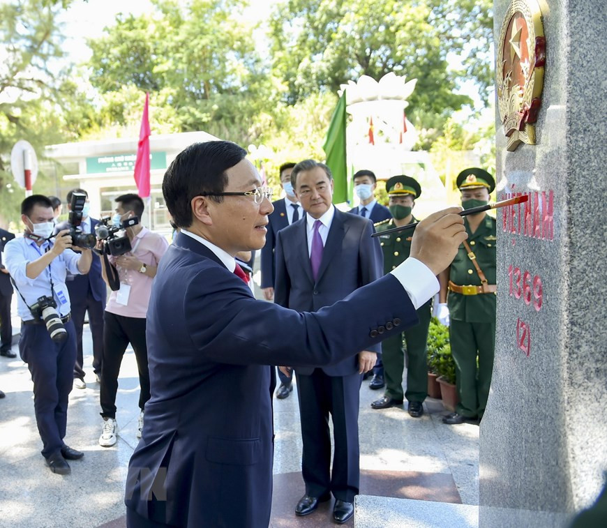 Deputy Prime Minister and Foreign Minister Pham Binh Minh paints on border landmark 1369 under Chinese State Counsellor and Foreign Minister Wang Yi’s witness (Photo: VNA)
