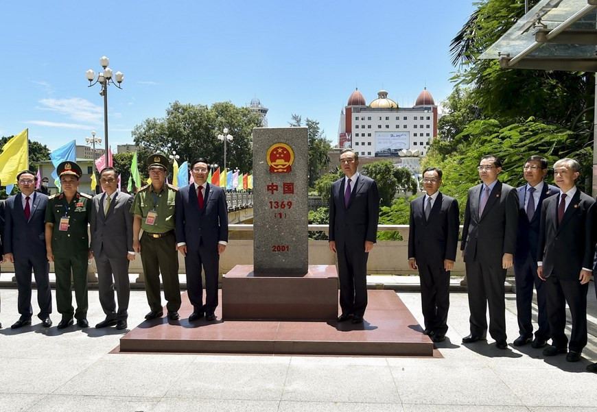 Deputy Prime Minister and Foreign Minister Pham Binh Minh (left) and Chinese State Counsellor and Foreign Minister Wang Yi visit border landmark 1369 in China. (Photo: VNA)