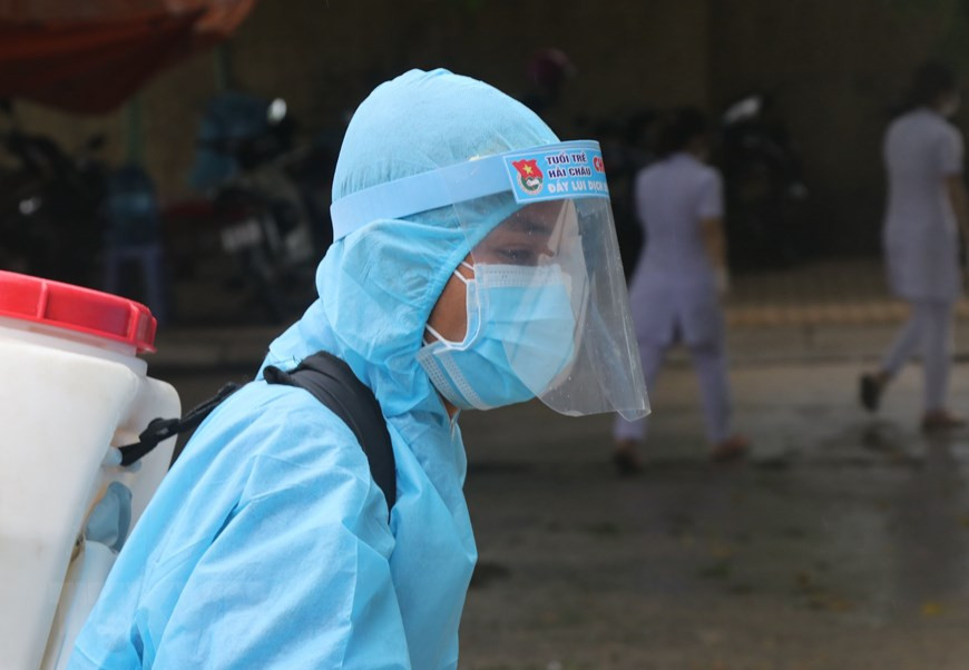 Medical staff spray disinfectant on vehicles going in and out the field hospital (Photo: VNA)