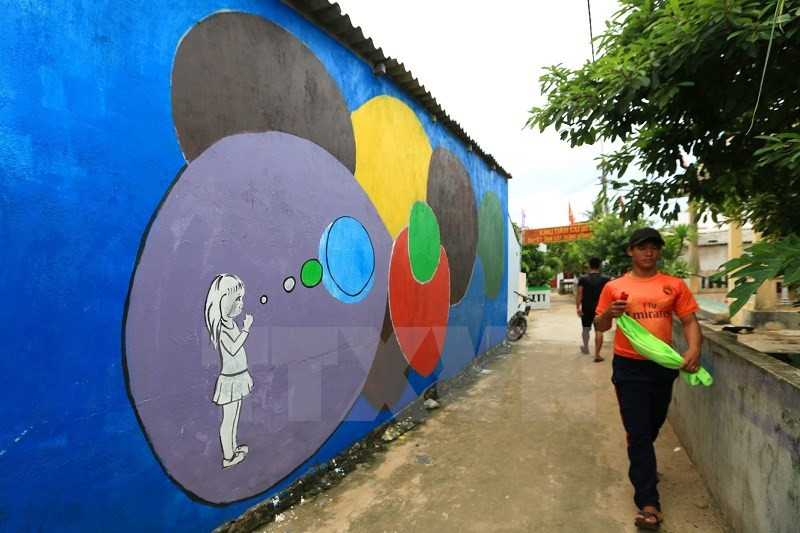 Young artists from Hanoi and HCM City - volunteers of the International Union for Conservation of Nature, the Ly Son Nature Reserve and local authorities launch the mural artwork project in a village on Be island (Source: VNA)