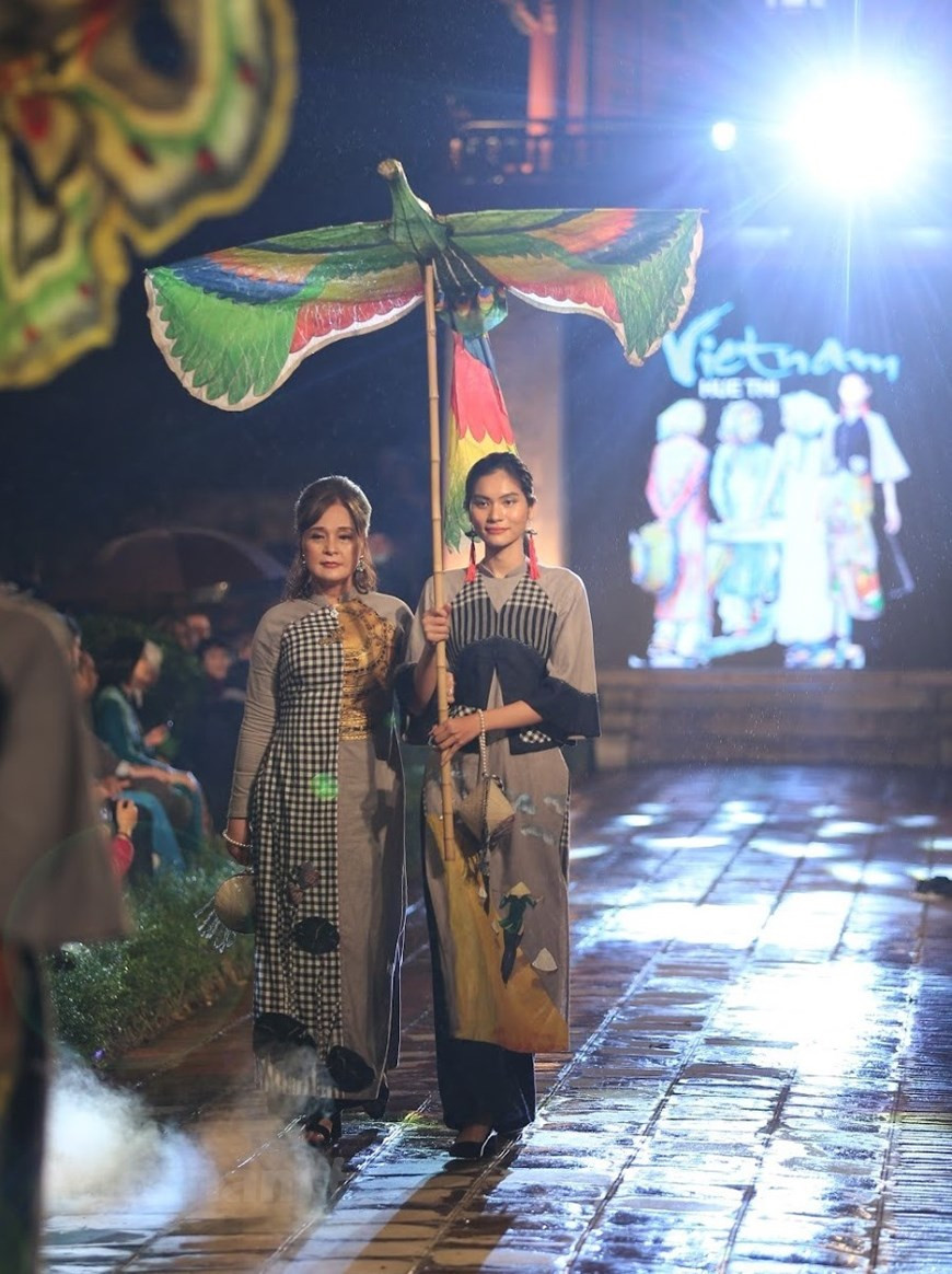Joining models in the show are outstanding actresses of Vietnam. The word ‘ao dai’ has been included in the Oxford dictionary, which explains ‘ao dai’ is a Vietnamese woman’s long-sleeved tunic with ankle-length panels at front and back, worn over trousers. The tunic is worn on various occasions, from family gatherings to diplomatic events, art performances, festivals, especially the traditional Tet (Lunar New Year) holiday, fashion shows and beauty contests, both at home and abroad. While it is simple to wear, the costume highlights the beauty of women. ‘Ao dai’, therefore, has become a popular attire of Vietnamese women. It has been an endless source of inspiration for movies, music and fine art. (Photo: VietnamPlus)