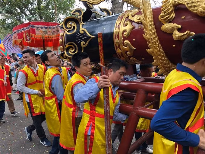 From early morning, local men carried firecrackers of 6 and 5.8 metres long, which were decorated with dragons, unicorns, tortoises and phoenixes to the village traditional house. The giant firecrackers would be taken to the village commune house in a procession. (Photo: VNA) 