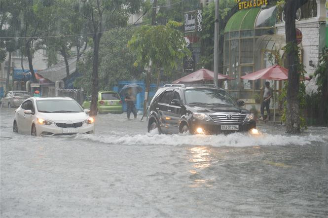Local police officers were stationed at street sections to direct vehicles, helping them avoid potholes and heavily flooded areas (Photo: VNA)