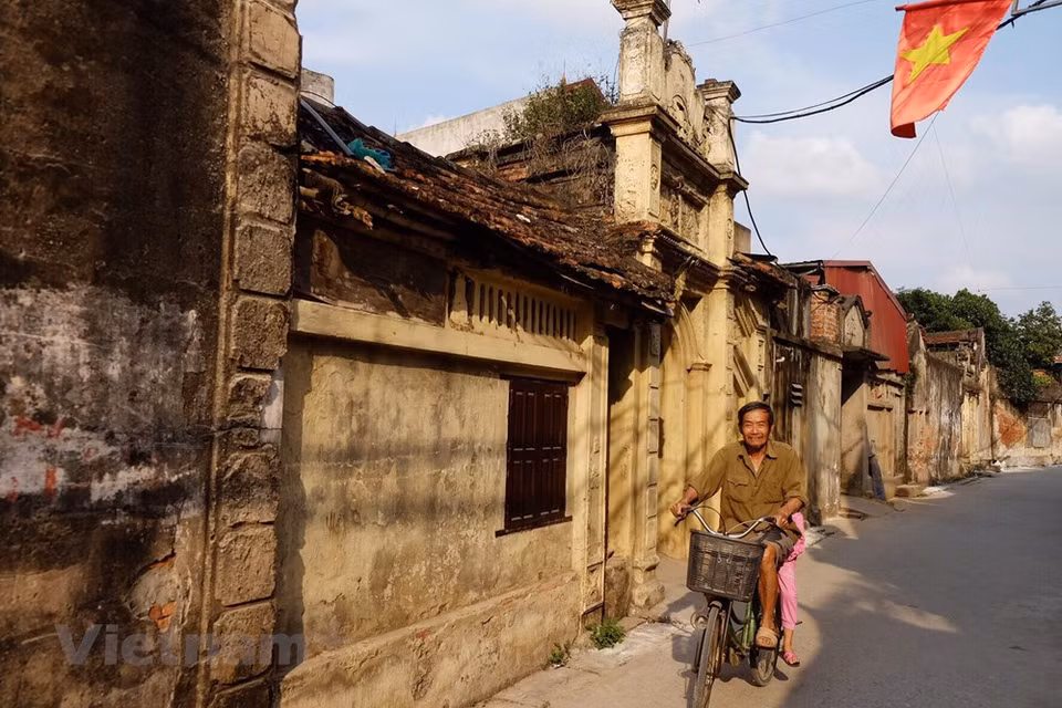 Many villas are in French style, but Cuu village still retains Asian-style architecture with winding alleys. Many people call Cuu village the "West village", because the village's architecture is perhaps different and outstandingly beautiful compared to the familiar old villages of the North. Going around Cuu village, suddenly you will hear the sound of rustling bamboo brooms, barking dogs and the slight wind. Walking around the blue stone path, narrow alleys of the Cuu village, we not only feel peaceful, calm but also mixed with an ancient and taciturn style. Quiet space also makes the atmosphere gloomy. The golden age of the Cuu village was a long time ago, but somewhere we always feel the bustling, wealth of “Tailor Village of Hanoi”. The time in the Cuu Village seems slower as if it remained the roof of the ancient values in this land. (Photo: PV / Vietnam+)