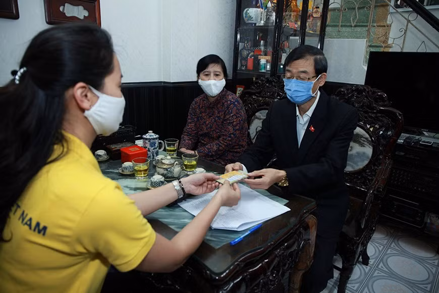 The Hanoi Post Office ensures the safe payment to the beneficiaries at their houses in Cua Dong Ward, Hoan Kiem District, April 16 (Photo: Vietnam +)