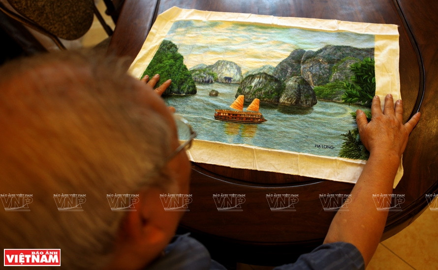 Artisan of Quat Dong embroidery artisan introduces Ha Long Bay's natural landscape painting to international friends (Photo: VNA)
