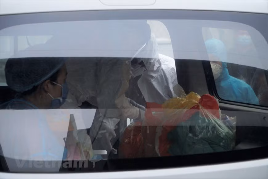 Doctors bring the baby and essential equipment to the car (Photo: Minh Hieu/Vietnam+)