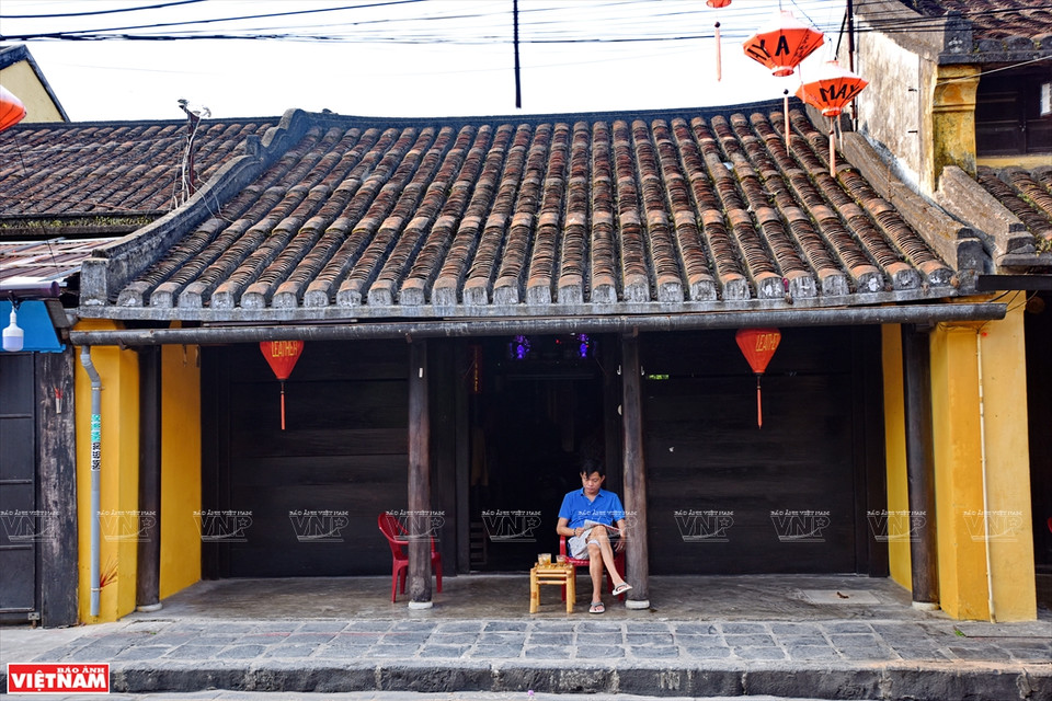 A man enjoys reading and having coffee in front of his house (Photo: Vietnam Pictorial/VNA)