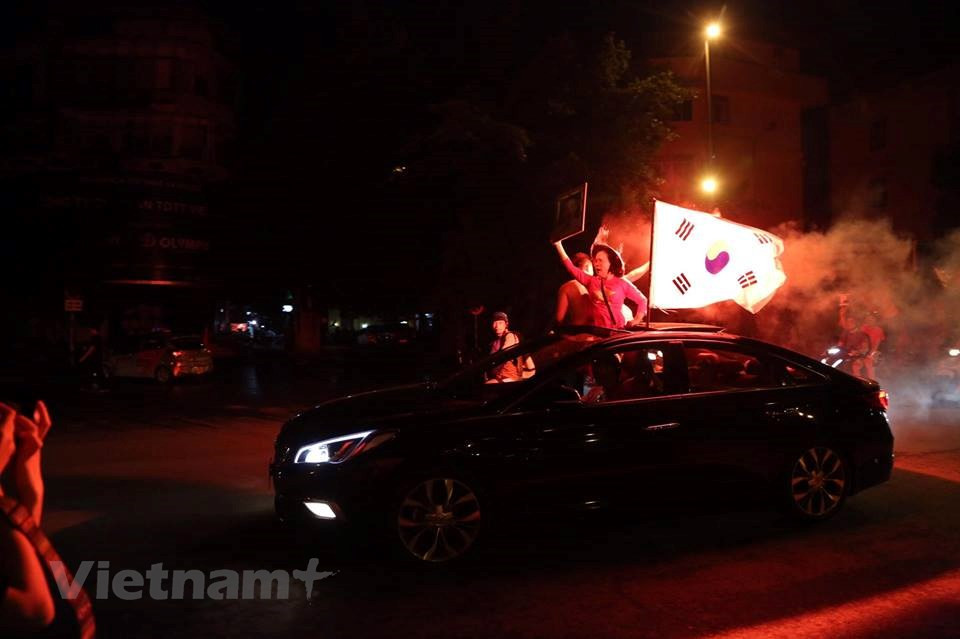 Football fans also raise the flag of the Republic of Korea, the nationality of coach Park Hang-seo (Photo: VNA)