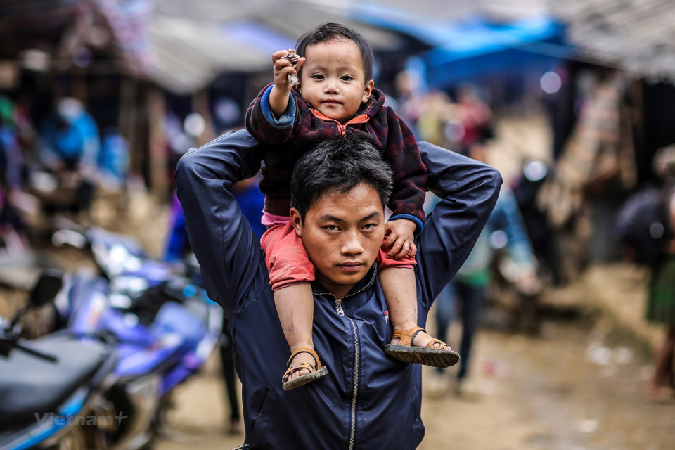 Many children follow their parents to go to the market (Photo: VNA)