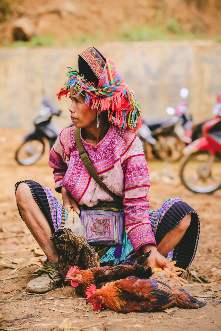 A woman sells chickens at Can Cau Market. Products at the market are mainly agricultural products like sugarcane, bee honey, alcohol, corn, buffaloes, and brocade (Photo: VNA)