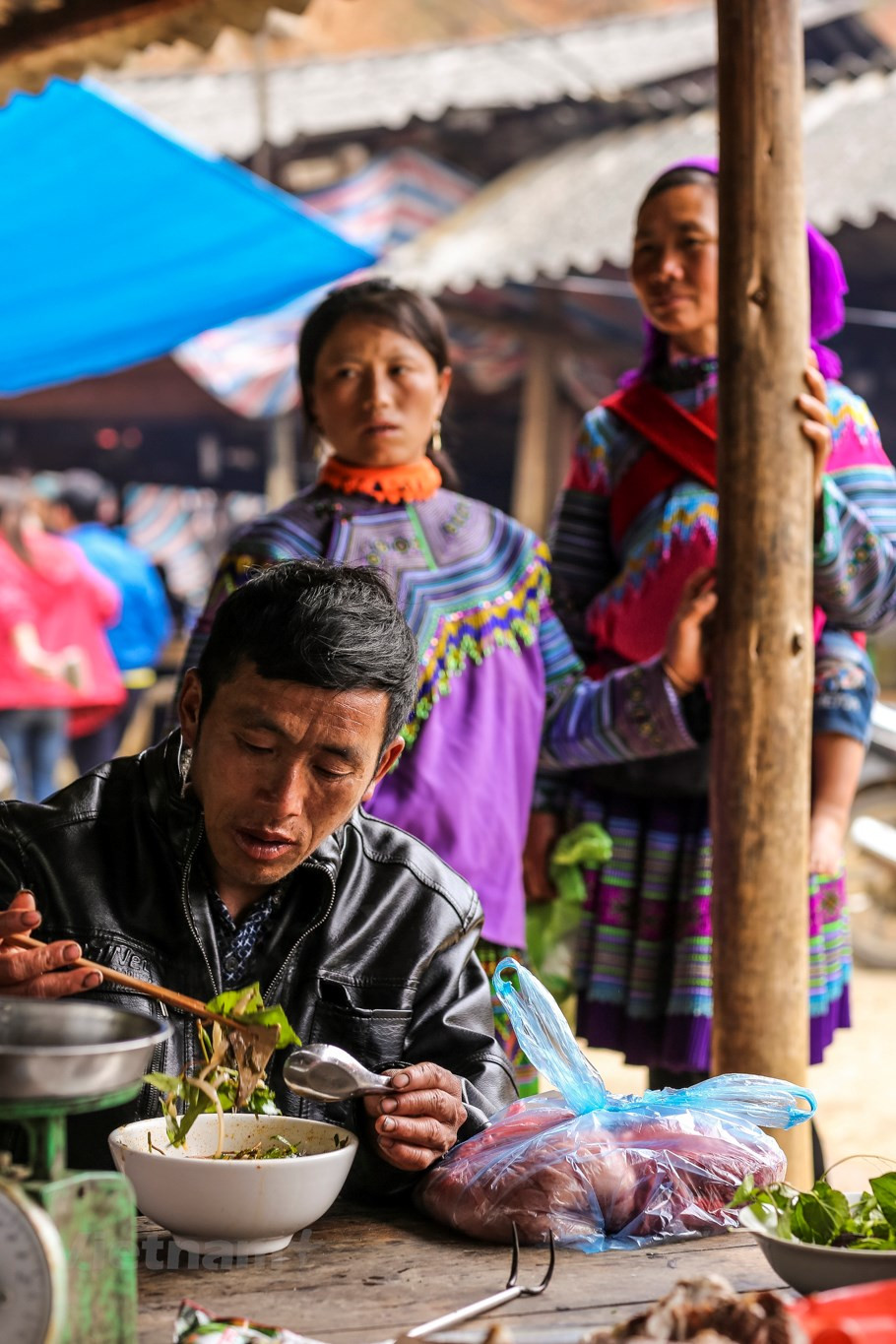 A man enjoys a bowl of noodles at the market (Photo: VNA)