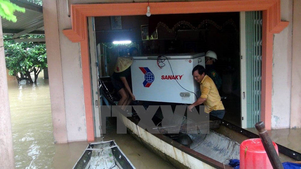 People help a local family evacuate assets in a flooded area in Quang Tri province (Photo: VNA)