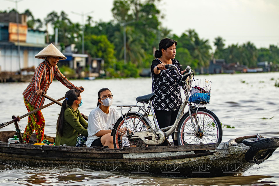 Ferrying students and local people across the river is part of the vibrant scene at Nga Nam floating market. (Photo: VPA/VNA)