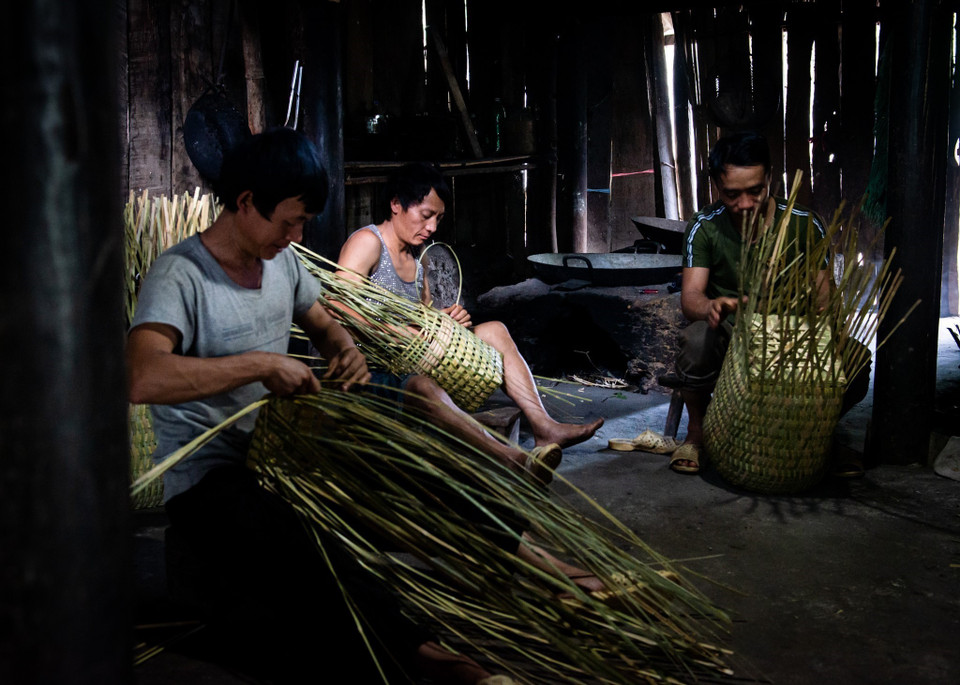 They weave the baskets after sharpening and splitting bamboo slats. (Photo: VNA)