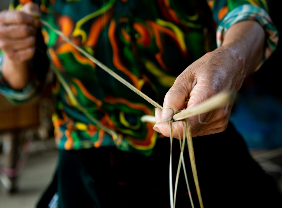 The Mong women split the threads carefully to obtain sheaths. The flax sheaths are then crushed in stone mortars to soften them until only the tough threads remain. After being boiled several times in water mixed with ash and beeswax, the linen threads become softer and whiter. This is when the Mong women work with their looms. (Photo: VNA)